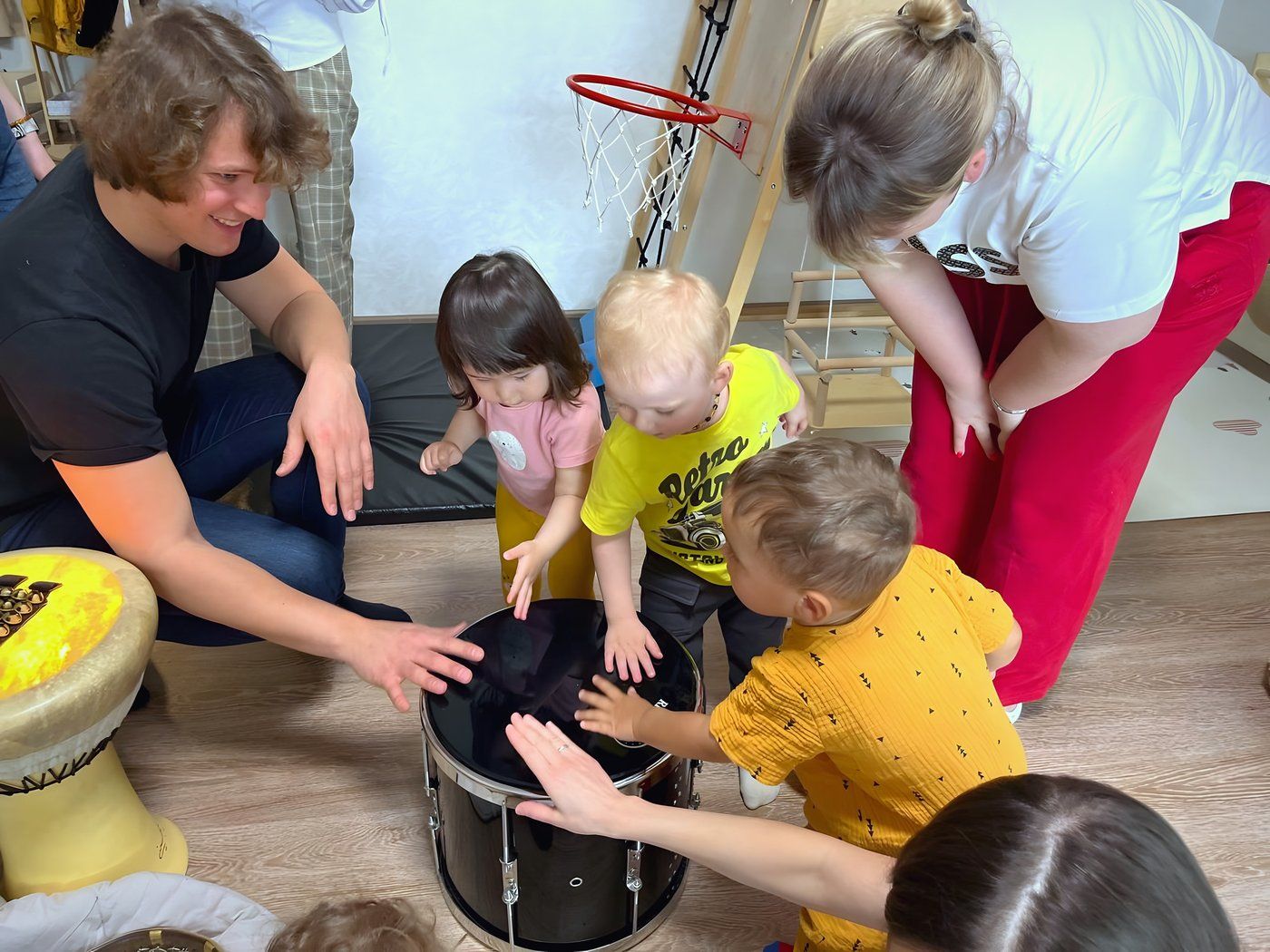 Erik Markovsky helping toddlers feel the sound of a drum